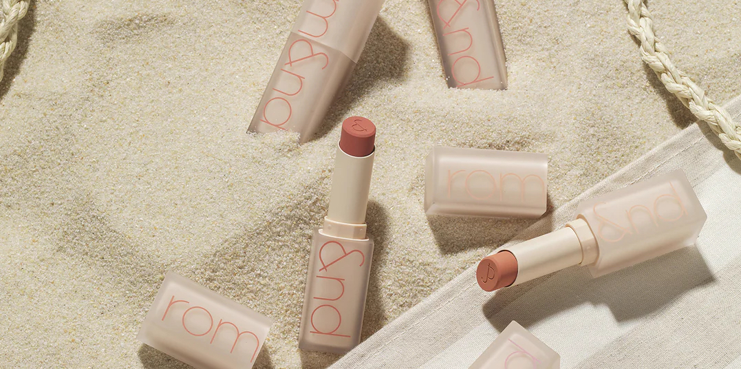 Lipsticks on sandy background.